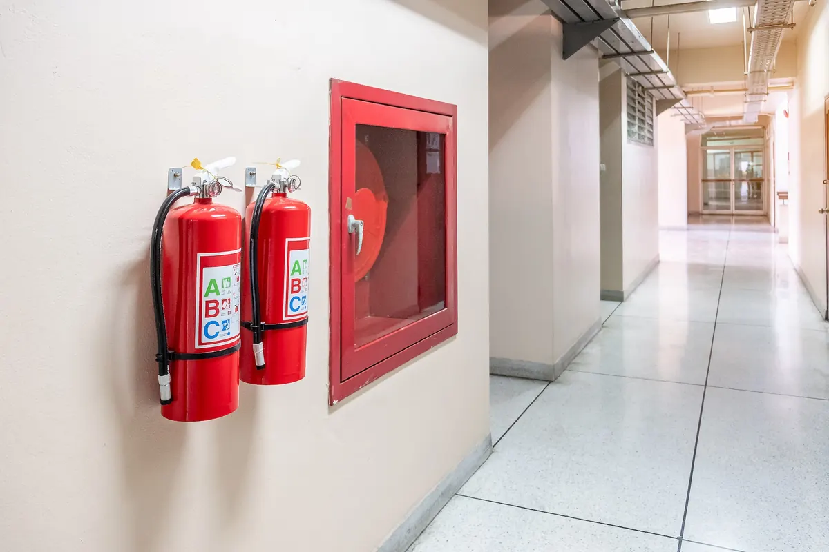Extintores y boca de incendio equipada en un pasillo